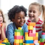 Smiling kids playing with multi colored toy blocks generated by artificial intelligence